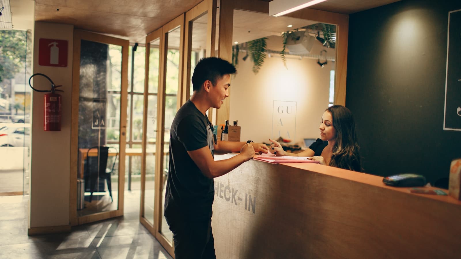 Receptionist e ospite al banco check-in di un hotel